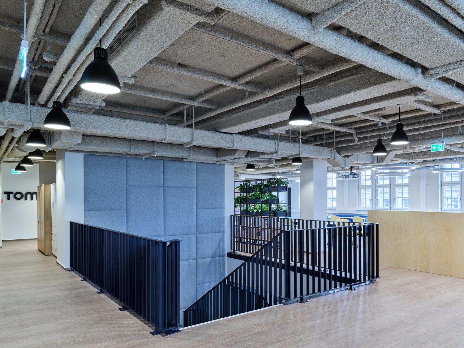 Spacious modern office interior with acoustic wall panels and industrial ceiling design